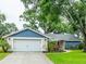 Charming single-Gathering home features a well-manicured lawn, mature trees, and an attached two-car garage at 14902 Foxhound Pl, Tampa, FL 33624