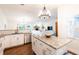 Open kitchen with stainless steel appliances, granite countertops, white cabinets, and a central island at 14902 Foxhound Pl, Tampa, FL 33624