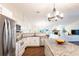 Bright, modern kitchen featuring stainless steel appliances and granite countertops, open to the living room at 14902 Foxhound Pl, Tampa, FL 33624