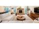 Inviting living room with stone fireplace, modern furniture, decorative rug, and natural light from the backyard at 14902 Foxhound Pl, Tampa, FL 33624