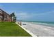 Relaxing white sand beach for building residents featuring grassy areas, a walkway, and ocean views at 16330 Gulf Blvd # 201, Redington Beach, FL 33708