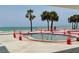 Inviting pool surrounded by palm trees and the ocean, perfect for relaxation and recreation at 16330 Gulf Blvd # 201, Redington Beach, FL 33708