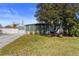 Well-maintained home featuring a lush green lawn and sunroom, shaded by a mature tree at 1701 66Th N Ave, St Petersburg, FL 33702