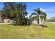 Well-maintained front yard showcases lush green grass, tropical plants, and a tidy landscape design at 1701 66Th N Ave, St Petersburg, FL 33702