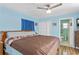 Spacious main bedroom features wood flooring, blue walls, ceiling fan, and bathroom access at 1701 66Th N Ave, St Petersburg, FL 33702