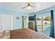 Bright bedroom boasts a ceiling fan, wooden dresser, closet, and a sliding door to the pool area at 1701 66Th N Ave, St Petersburg, FL 33702