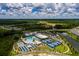 Magnificent aerial image showcasing a community's sparkling pools, tennis courts, verdant landscaping, and other common areas at 17263 Mango Shay Ct, Land O Lakes, FL 34638