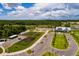 An aerial view of a community farm with parking, garden plots, a greenhouse, and a charming farmhouse-style building at 17263 Mango Shay Ct, Land O Lakes, FL 34638