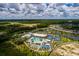 Aerial view showcasing a community's resort-style pool, tennis courts, and lush green spaces perfect for outdoor activities at 17263 Mango Shay Ct, Land O Lakes, FL 34638