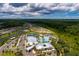Community aerial view featuring the pool, clubhouse, parking, tennis and pickleball courts, and nearby forest at 17263 Mango Shay Ct, Land O Lakes, FL 34638