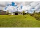 Lush green backyard with a view of neighboring houses under a partly cloudy sky at 17263 Mango Shay Ct, Land O Lakes, FL 34638