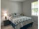 Comfortable bedroom with a patterned bedspread, a window, and ample natural light at 17263 Mango Shay Ct, Land O Lakes, FL 34638