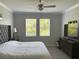 Bright main bedroom featuring a ceiling fan, large windows, and an upholstered headboard at 17263 Mango Shay Ct, Land O Lakes, FL 34638