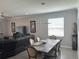 Dining area with a large table, six chairs, modern lighting, and neutral decor at 17263 Mango Shay Ct, Land O Lakes, FL 34638