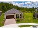 Aerial view of a charming one-story home featuring a brick driveway, two-car garage, and manicured landscaping at 17263 Mango Shay Ct, Land O Lakes, FL 34638