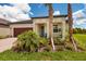 Inviting front exterior with a well-manicured lawn, a blue door, and lush landscaping at 17263 Mango Shay Ct, Land O Lakes, FL 34638