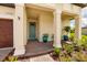 Inviting front porch with stylish brick flooring, columns, and colorful potted plants adding charm to the entrance at 17263 Mango Shay Ct, Land O Lakes, FL 34638