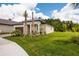 Beautifully landscaped front yard with lush green grass, palm trees, and meticulous plantings showcasing curb appeal at 17263 Mango Shay Ct, Land O Lakes, FL 34638