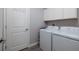 Functional laundry room showcasing a white washer and dryer, cabinets, and neutral walls at 17263 Mango Shay Ct, Land O Lakes, FL 34638