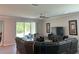 Spacious living room with a large sectional sofa, a ceiling fan, and a sliding glass door at 17263 Mango Shay Ct, Land O Lakes, FL 34638