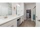 Elegant bathroom featuring double vanities with white cabinets, quartz counters and wood-look tile at 17263 Mango Shay Ct, Land O Lakes, FL 34638