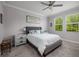 Serene bedroom with a ceiling fan, neutral tones, two windows, and plush carpeting at 17263 Mango Shay Ct, Land O Lakes, FL 34638