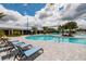 Resort-style pool area featuring lounge chairs, palm trees, and a zero entry pool for Gathering fun and relaxation at 17263 Mango Shay Ct, Land O Lakes, FL 34638