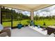 Inviting screened porch with views of a well maintained lawn and wooded area, perfect for relaxing outdoors at 17263 Mango Shay Ct, Land O Lakes, FL 34638