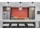 Chic kitchenette features a stylish red tile backsplash, modern appliances, and bar seating with pendant lighting at 199 Dali Blvd # 2, St Petersburg, FL 33701