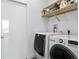 Modern laundry room with a stacked washer and dryer and wooden shelving at 199 Dali Blvd # 2, St Petersburg, FL 33701