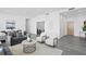 Open-concept living space with gray sofas, light-colored chairs, tiled floors, and contemporary decor at 199 Dali Blvd # 2, St Petersburg, FL 33701