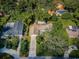 An aerial view of a home surrounded by lush greenery, showcasing the driveway, roof and landscape at 209 S Greenfield Ave, Temple Terrace, FL 33617