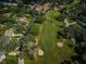An aerial view of a golf course community, featuring lush green fairways and verdant trees at 209 S Greenfield Ave, Temple Terrace, FL 33617