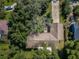 Aerial view of a home nestled among lush trees with driveway and partial view of the roof at 209 S Greenfield Ave, Temple Terrace, FL 33617
