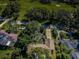 Aerial shot of property surrounded by trees, featuring a driveway and nearby homes at 209 S Greenfield Ave, Temple Terrace, FL 33617
