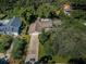 An aerial view of a single Gathering home surrounded by lush greenery and a long driveway at 209 S Greenfield Ave, Temple Terrace, FL 33617