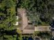 An aerial view of a home with mature landscaping and partial view of the roof at 209 S Greenfield Ave, Temple Terrace, FL 33617