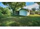 A charming green house featuring a screened patio and a lush green lawn at 209 S Greenfield Ave, Temple Terrace, FL 33617