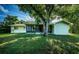 A beautiful house featuring a screened patio and a spacious green lawn shaded by a large tree at 209 S Greenfield Ave, Temple Terrace, FL 33617