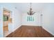 Bright dining room showcasing hardwood floors, an elegant chandelier, and natural light through window at 209 S Greenfield Ave, Temple Terrace, FL 33617