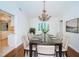 Elegant dining room featuring a crystal chandelier, modern table with seating for eight, and hardwood floors at 209 S Greenfield Ave, Temple Terrace, FL 33617