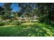The exterior of a lovely home with mature trees, a spacious lawn, and meticulous landscaping at 209 S Greenfield Ave, Temple Terrace, FL 33617