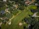 Overhead view of a green golf fairway near homes, complete with two sand traps, surrounded by mature trees at 209 S Greenfield Ave, Temple Terrace, FL 33617