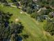 Scenic aerial view of a golf course fairway, lined with mature trees and bordered by residential homes at 209 S Greenfield Ave, Temple Terrace, FL 33617