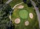 Aerial view of a pristine golf green, showcasing manicured grass, sand traps, and a winding cart path at 209 S Greenfield Ave, Temple Terrace, FL 33617