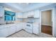 Well-lit kitchen equipped with white appliances, ample counter space, and tile flooring, ready for culinary adventures at 209 S Greenfield Ave, Temple Terrace, FL 33617
