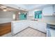Functional kitchen with white countertops, sink, and appliances, seamlessly integrated into the living space at 209 S Greenfield Ave, Temple Terrace, FL 33617