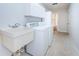 Laundry area with washer, dryer, sink, storage, and tile flooring at 209 S Greenfield Ave, Temple Terrace, FL 33617