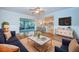 Bright living room featuring hardwood floors, access to the kitchen and sunroom, and stylish furniture at 209 S Greenfield Ave, Temple Terrace, FL 33617