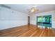 Bright living room with hardwood floors, wainscoting, a ceiling fan, and a sliding door to a sunroom at 209 S Greenfield Ave, Temple Terrace, FL 33617